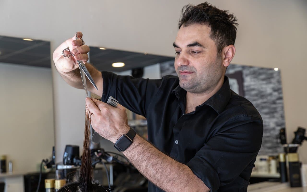 Ozzy cutting a client's hair at Riva Hairdressing